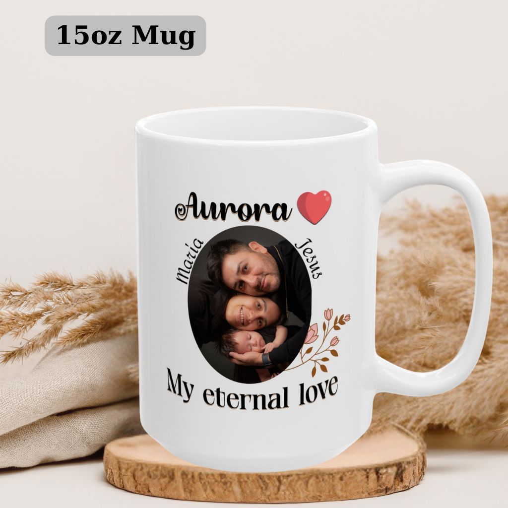 White mug with baby's name "Aurora", red heart, and floral motif, placed next to white flowers. 15oz Mug.