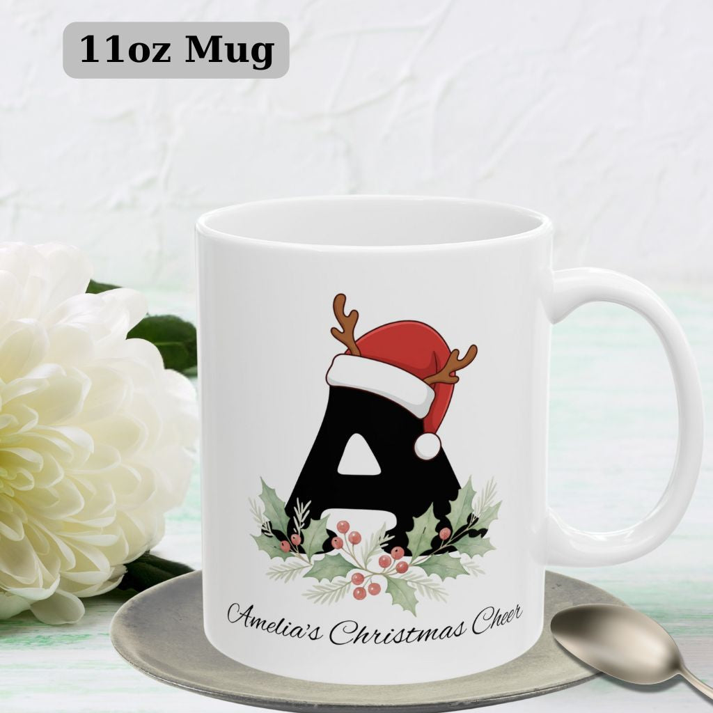 Red-handled 11oz Christmas mug featuring winter landscape and festive initial design.